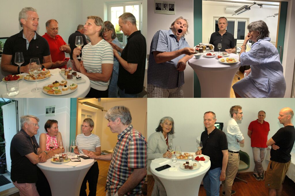 Collage aus vier Fotos eines geselligen Empfangs in einem hellen Innenraum. Mehrere Erwachsene stehen an Stehtischen mit Wein, Häppchen, Erdbeeren und kleinen Desserts und unterhalten sich. Auf einem Bild hält eine Person einen Teller mit Kuchen und macht einen überraschten Gesichtsausdruck. Die Atmosphäre wirkt freundlich und entspannt.